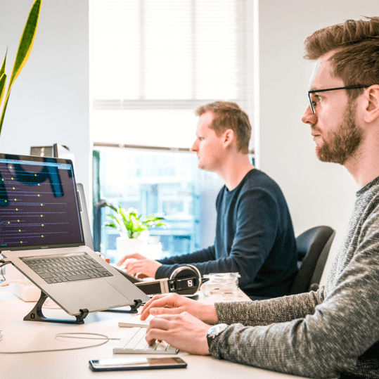 Two workers in front of laptops