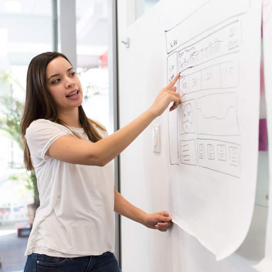 A female worker pointing at a storyboard